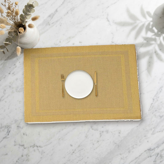 Set de table rectangulaire doré avec assiette sur une table en marbre